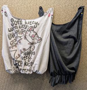Photo of two tote bags made from t-shirts. Right bag is dark gray with fringe, left bag is light gray with illustrated kitten.